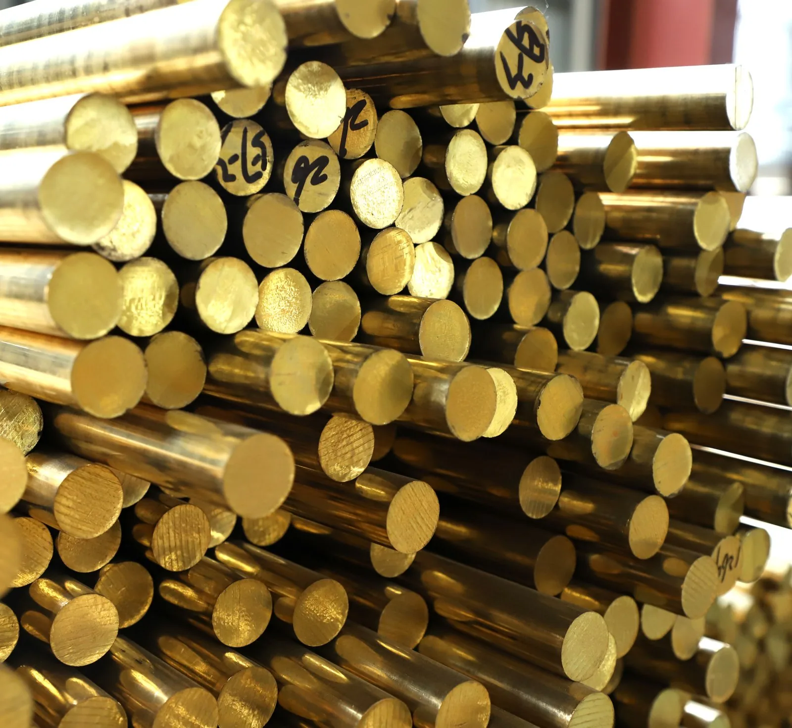Machined brass bar stock rods stacked in the Hitze production plant before forming into fittings