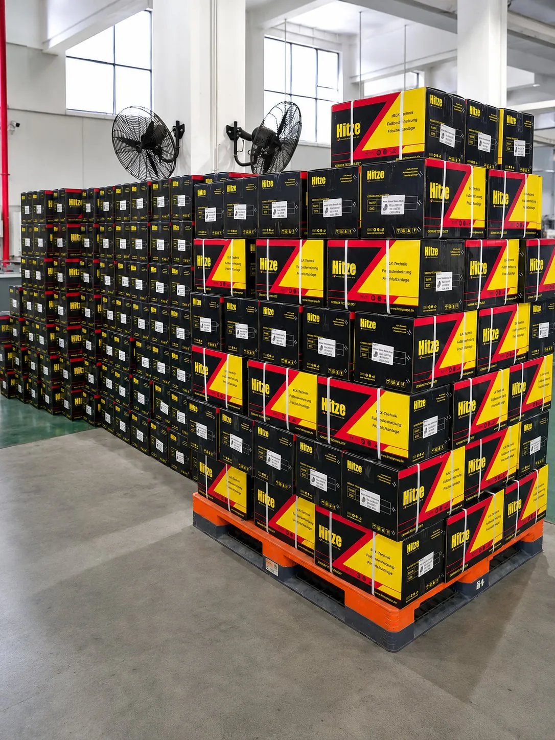 Branded export cartons of brass compression fittings stacked and strapped on a warehouse pallet