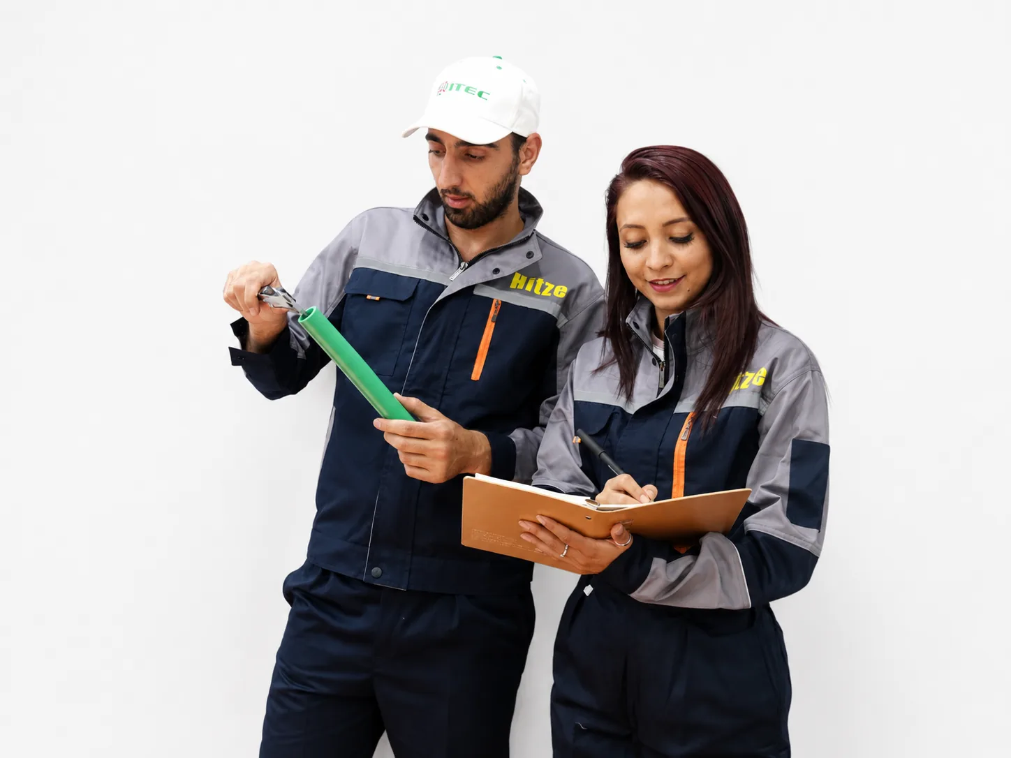 Hitze staff inspecting a green PPR pipe and recording quality notes