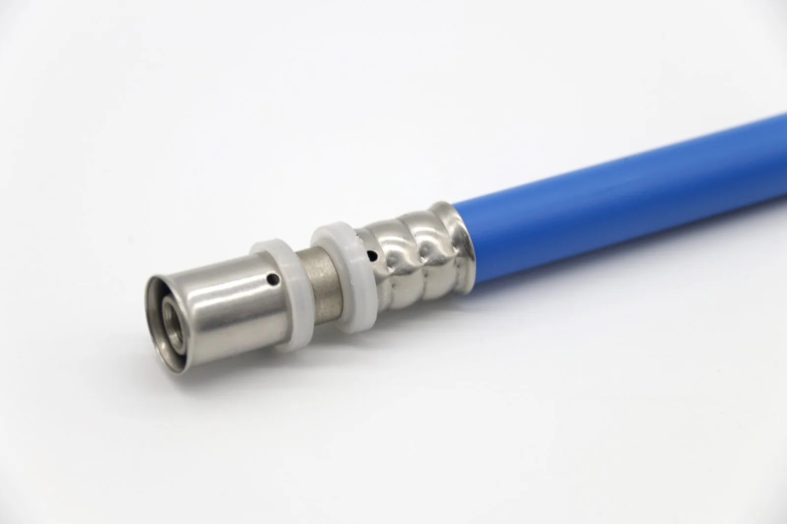 Multilayer PEX-AL-PEX pipe with a pressed brass fitting and stainless sleeve seated on the pipe end, forming a single-brand warrantable joint