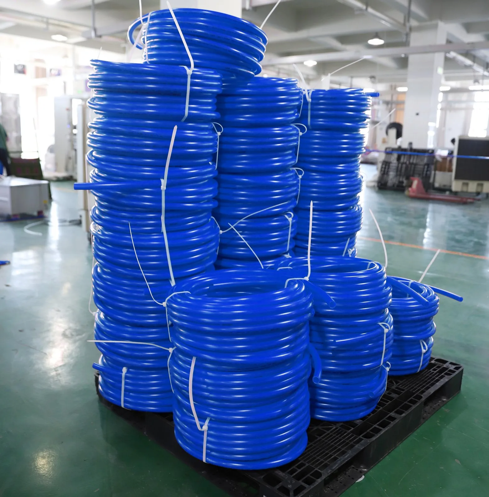 Blue PEX-b potable water pipe coils stacked on a pallet in the Hitze warehouse