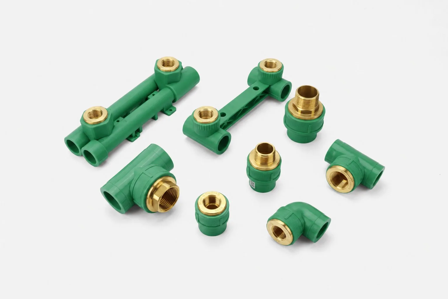 Green PP-R fitting family flat-lay showing sockets, elbows, tees, unions and brass-insert fittings
