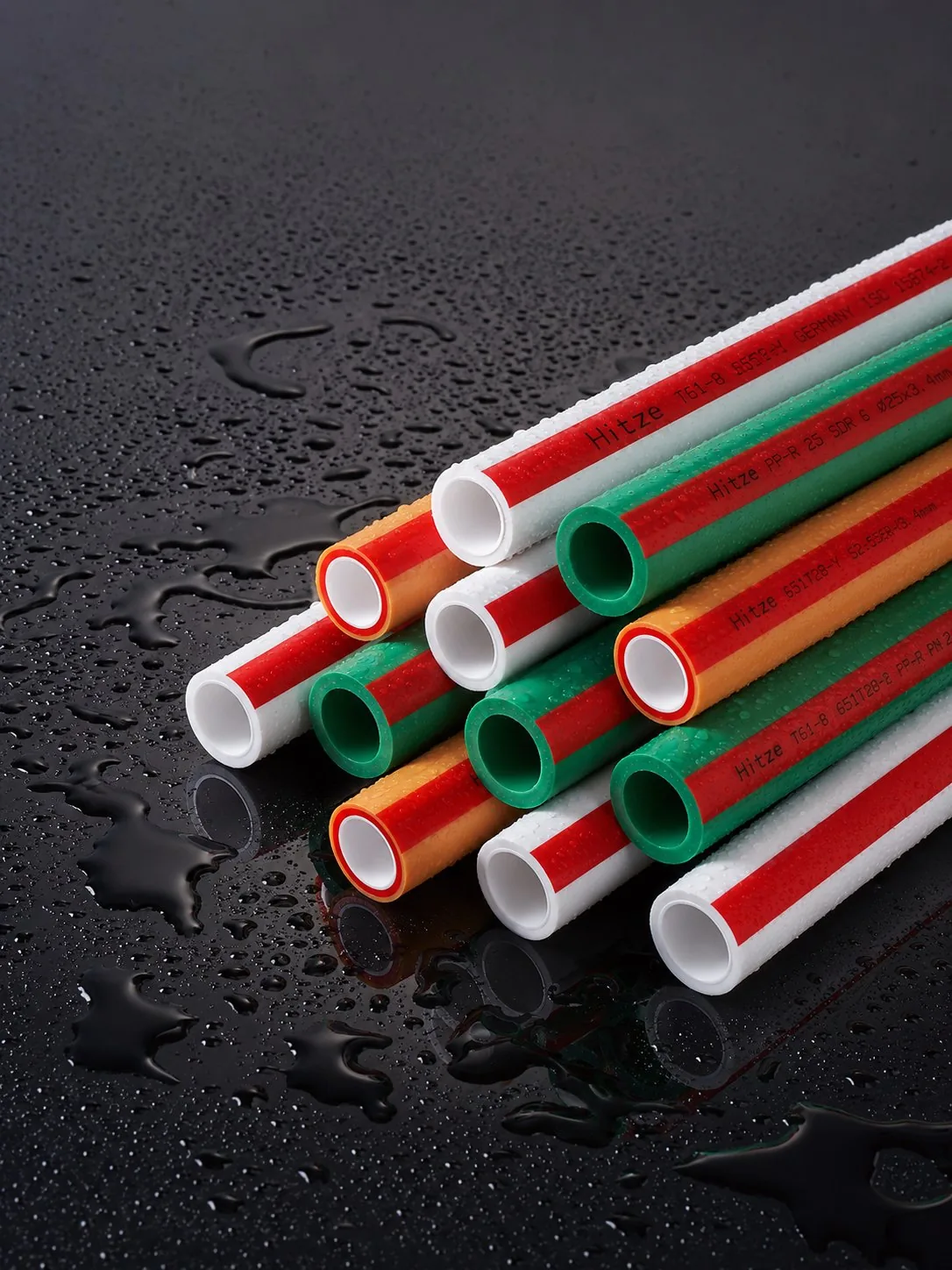 PP-R pipe ends stacked showing the size range across green, orange and white pipe types