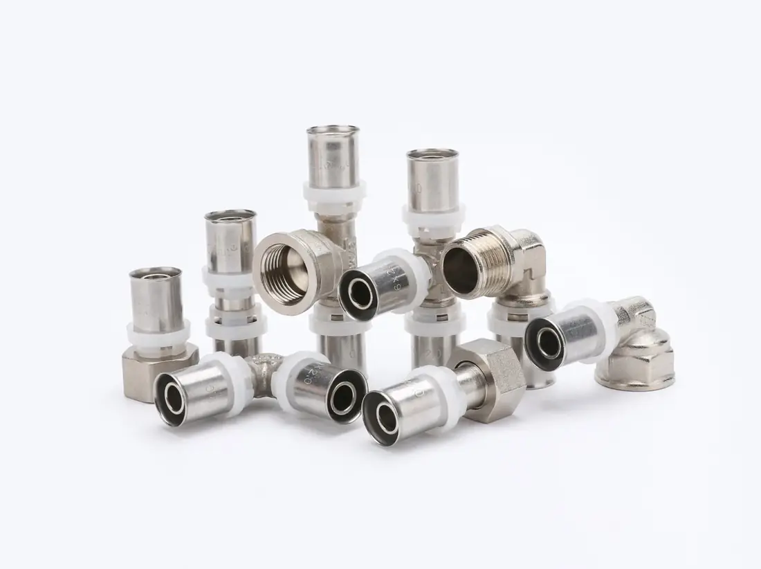 Group of lead-free brass press fittings and a stop valve for PEX and multilayer pipe on a white background