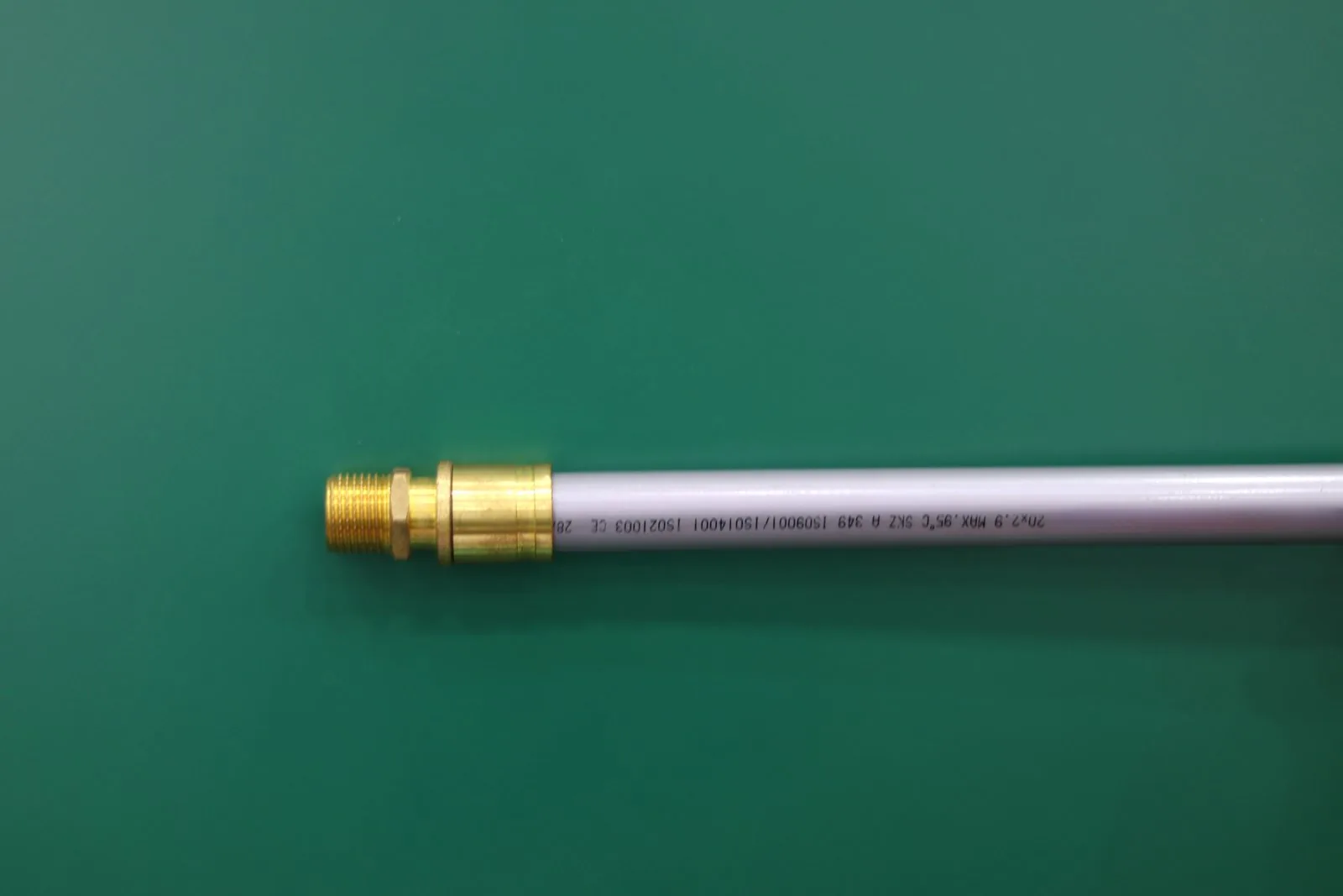 Push-fit fitting connected to pipe showing printed size and standard markings and the insertion depth reference