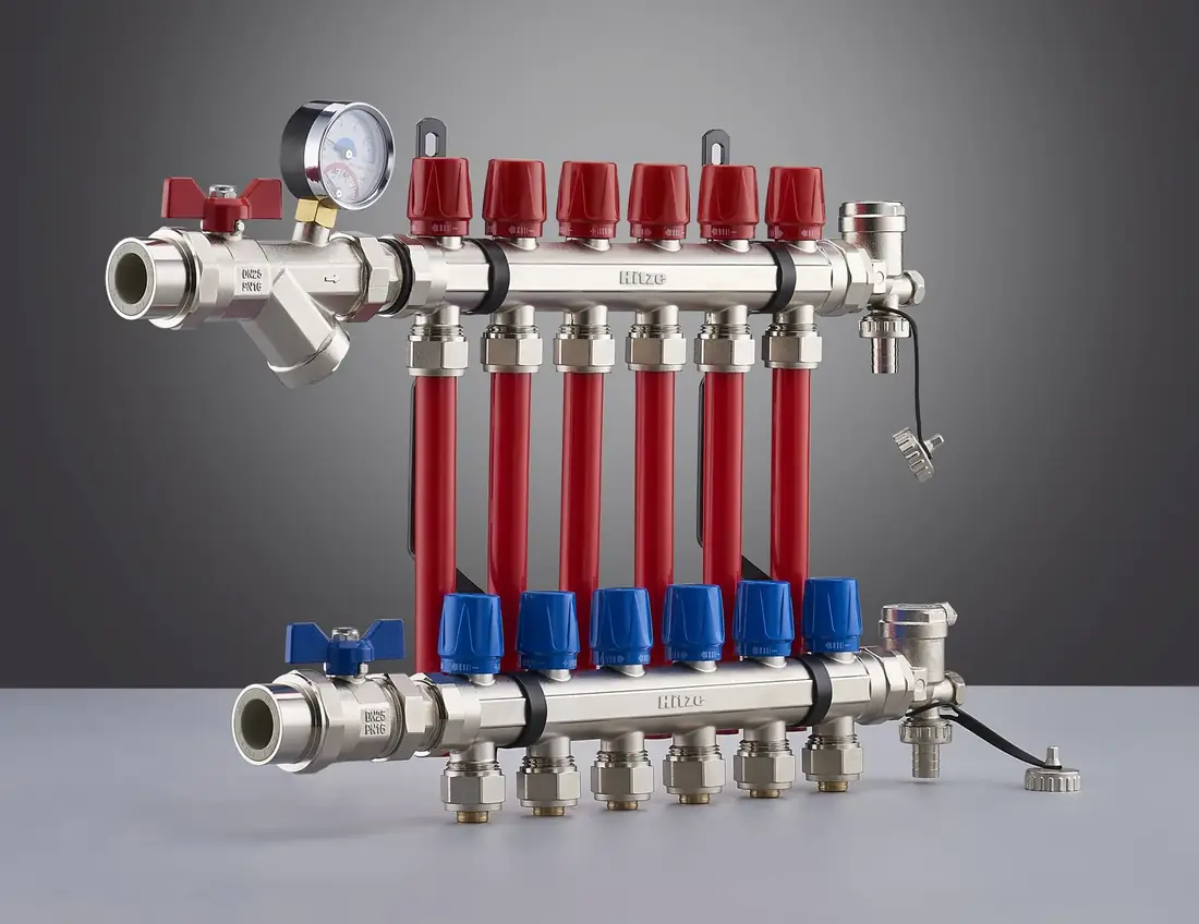 Brass and stainless steel underfloor heating manifold pair with red and blue actuator caps, flow meters and pressure gauge, front view