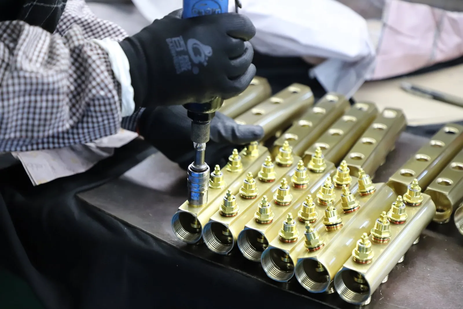 Several manifold bodies lined up in a row during assembly, showing how port count scales with body length