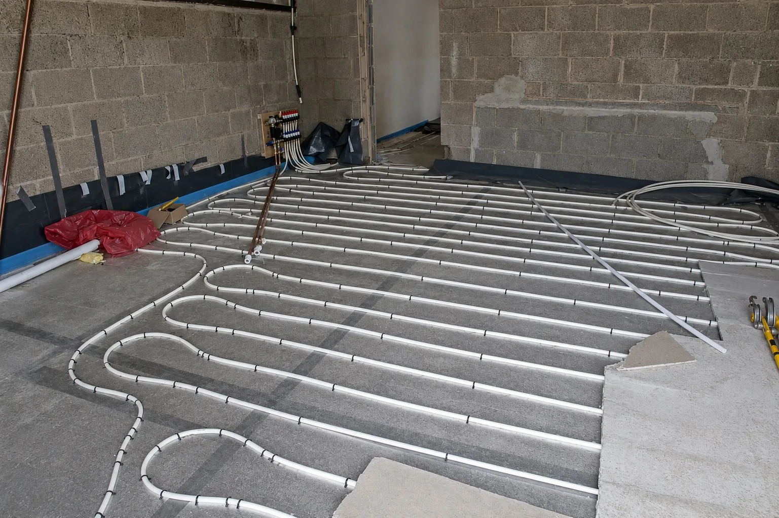 Radiant floor heating loops laid out and clipped on insulation panels before the screed pour